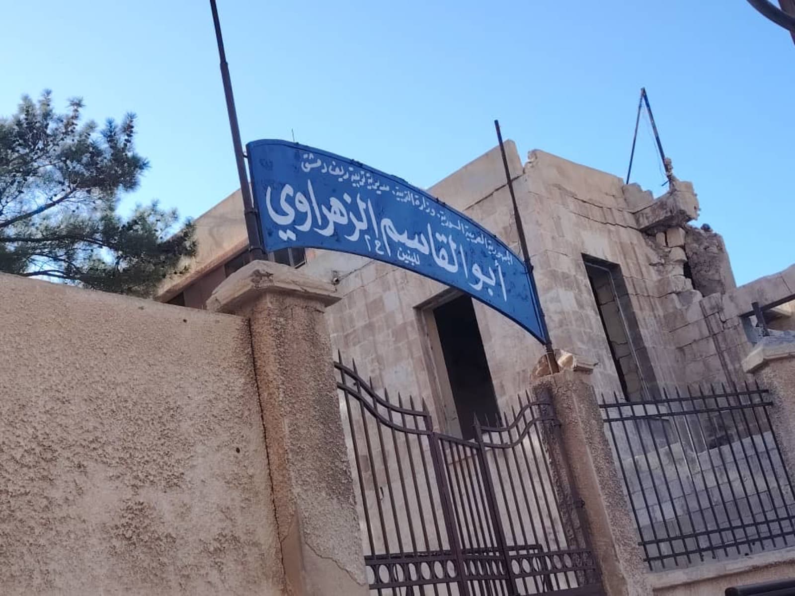 Eingangstor einer syrischen Schule unter klarem Himmel